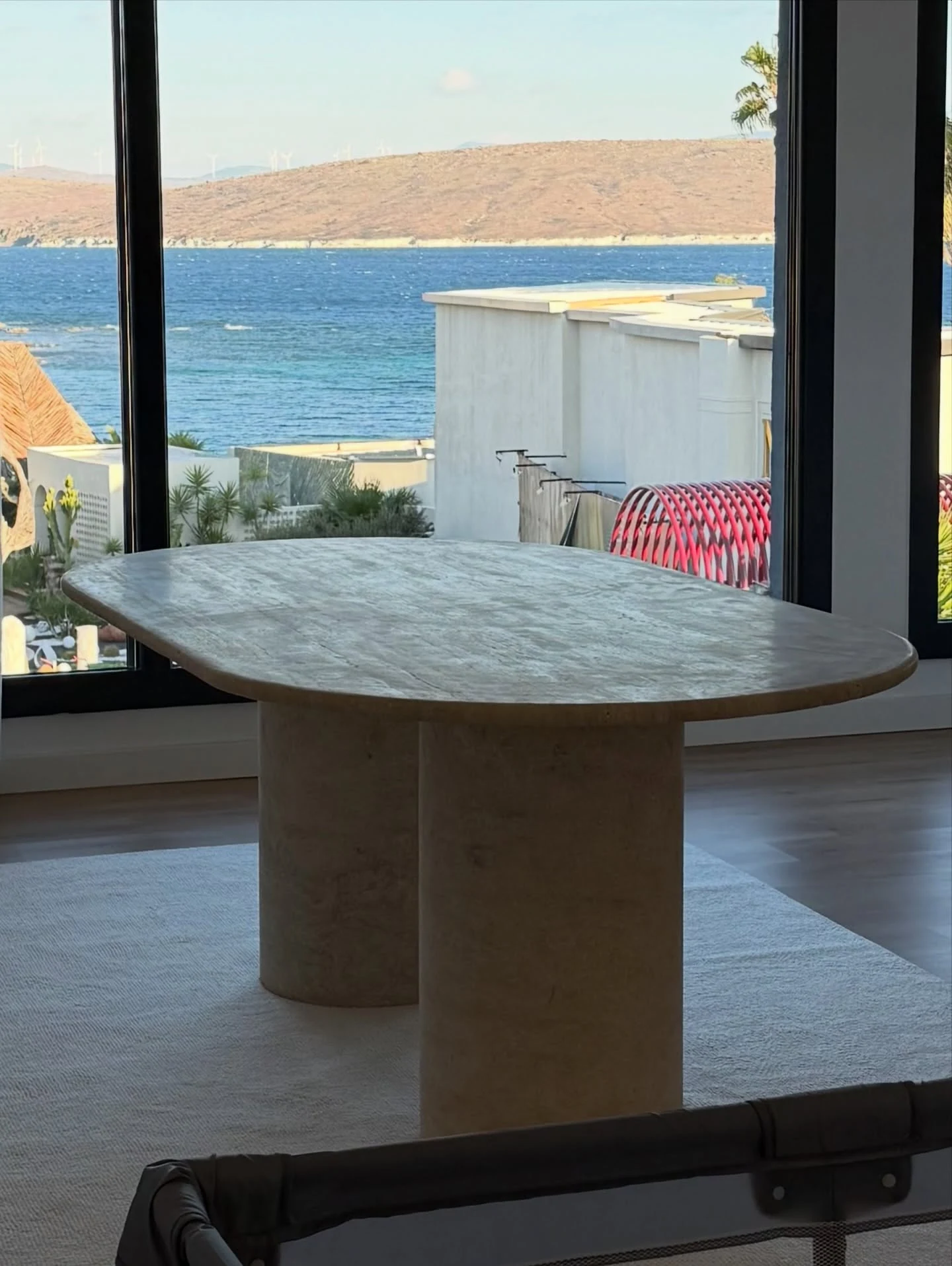Perge Dining Table in Light Travertine: oval top with broad curved/slab-like supports