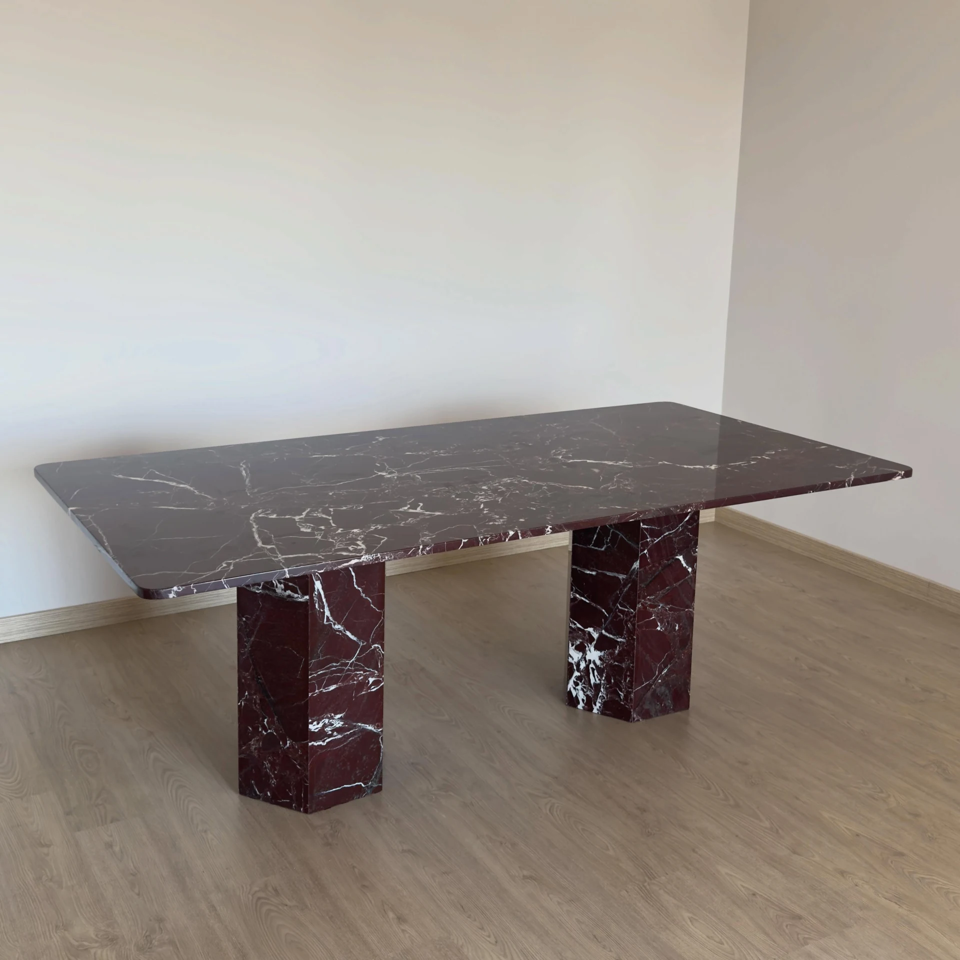 Rosso Levanto marble dining table: rounded-corner rectangular table with paired cylindrical legs